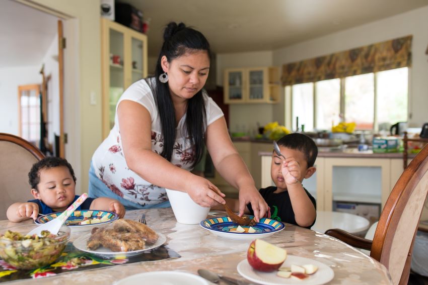 Pasifika woman helping children with food